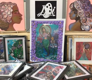 Colorful artwork featuring mermaids and women with intricate hair designs.