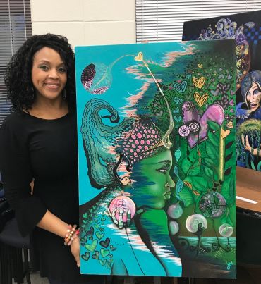 Woman proudly holding a vibrant, surreal portrait painting of a green-faced figure with intricate details.