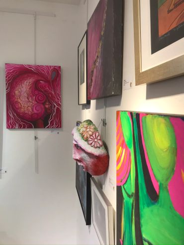 Colorful abstract paintings displayed in an art gallery corner.
