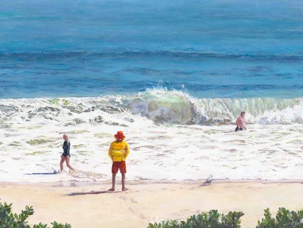 Lifeguard watches over beachgoers as waves crash on shore.