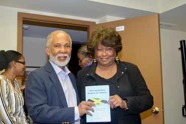 Two people holding a book