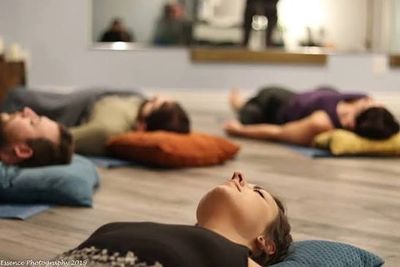 People lying down on cushions during a relaxation session.