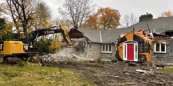 Excavator demolishing house 