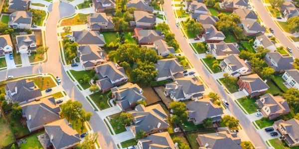 Aerial view of a suburban neighborhood with houses and greenery.