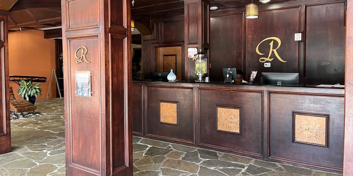 Elegant hotel reception with dark wood panels and stone flooring.