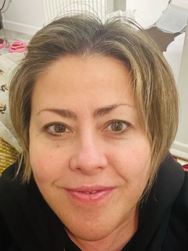 Close-up of a woman smiling gently at the camera.