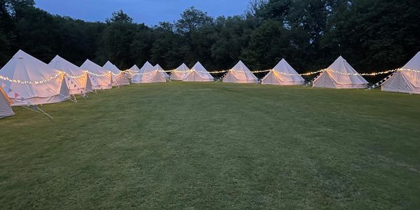 Bell tents with fairy lights at night