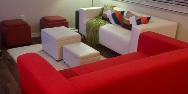 Modern living room with red and white sofas and colorful cushions.