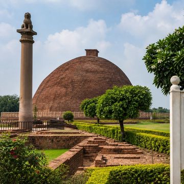 Vaishali World Heritage Site with ancient stupa and Ashokan pillar under a blue sky.