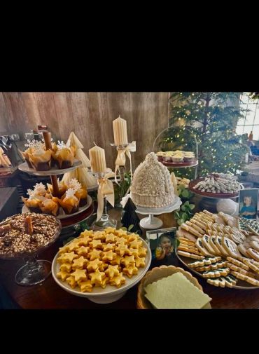 Festive dessert table with star-shaped cookies, cupcakes, and candles.