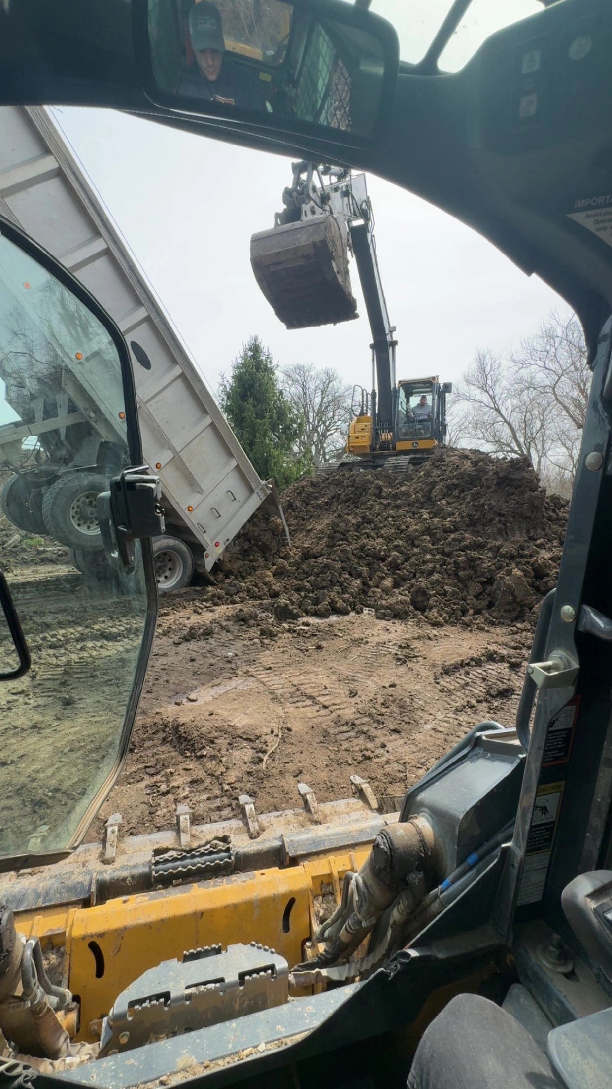 Excavator loading dirt from a dump truck at a construction site.