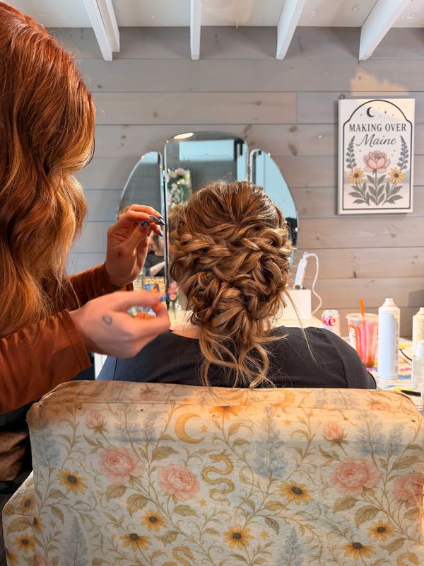 Intricate braided updo hairstyle being styled in a salon.