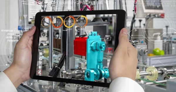 Person holding a tablet displaying augmented reality of machinery.