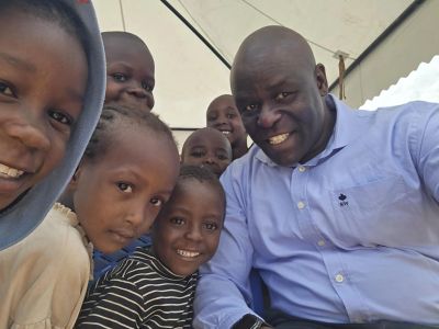 Group selfie of happy children and a man.