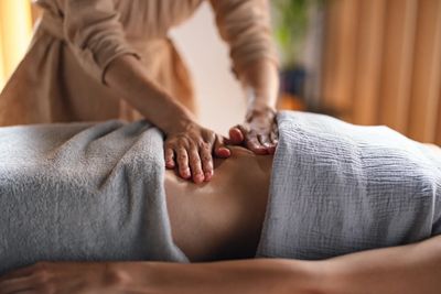 Person receiving a back massage covered with a towel.