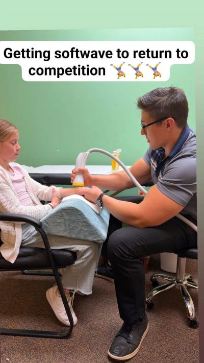 Therapist treating patient's arm with softwave therapy.
