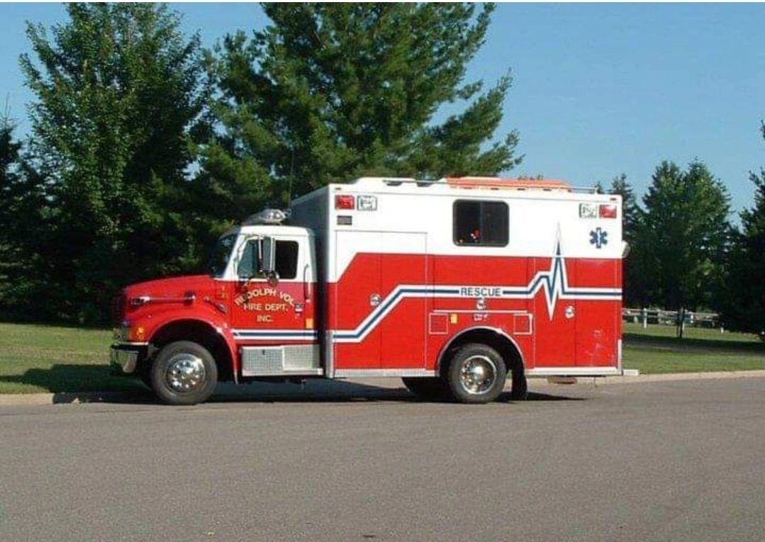 Red and white rescue fire department truck parked on a street.