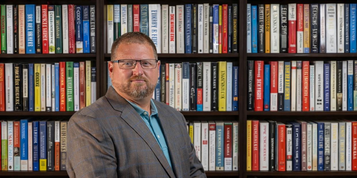 Scott Thompson in front of book case