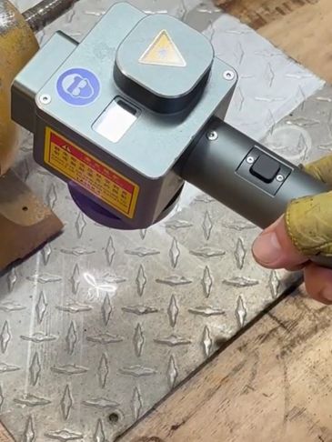 Handheld laser engraving machine marking metal sheet.