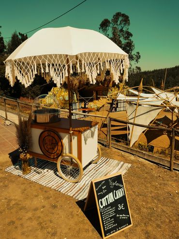 Cotton candy cart with boho decoration and a boho umbrella at the festival