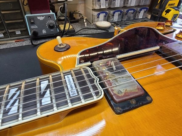 "Guitar repair bench with tools and a disassembled guitar."