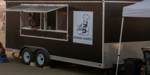 A food truck named Redneck Ramen with a person inside.