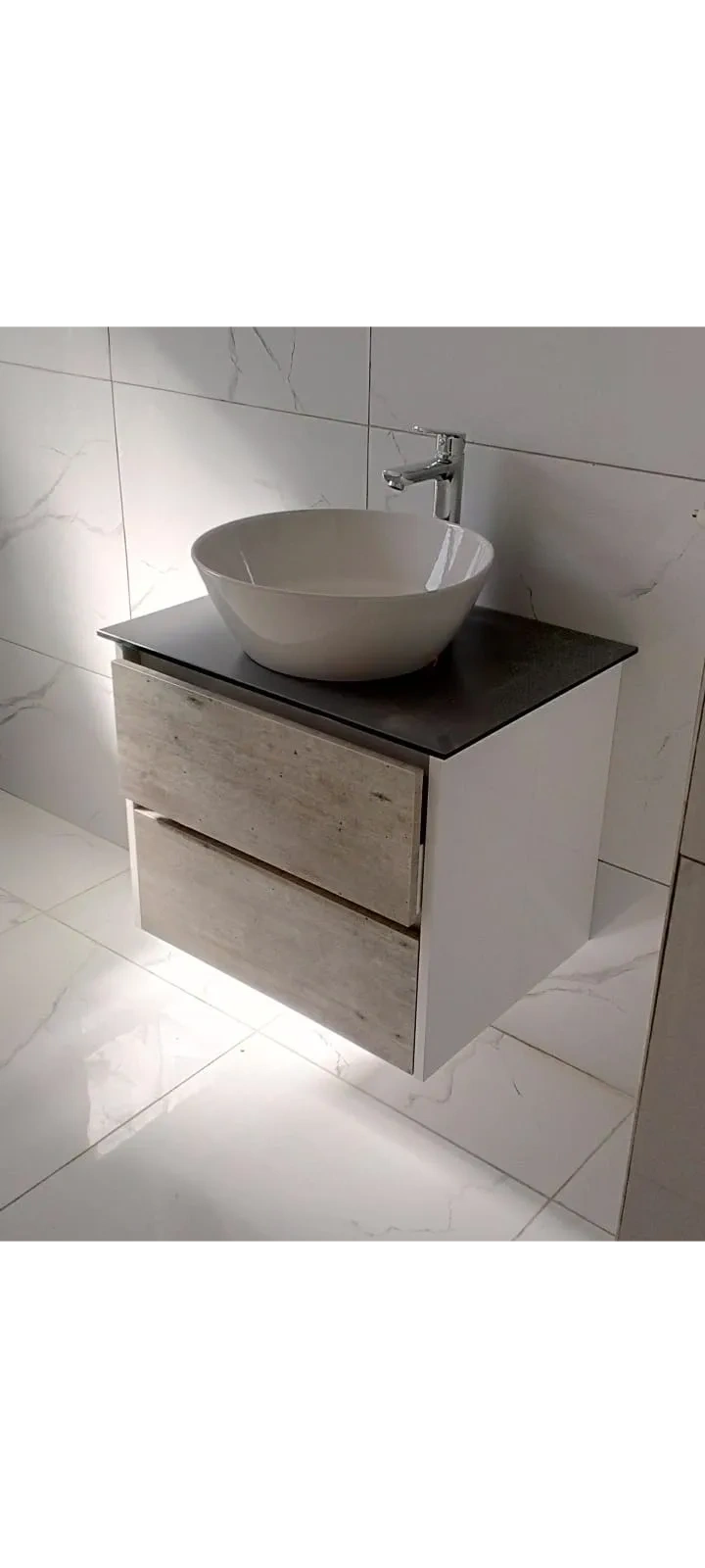 Modern bathroom vanity with a vessel sink and wood-finish drawers.