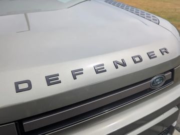 Close-up of a Land Rover Defender hood logo.