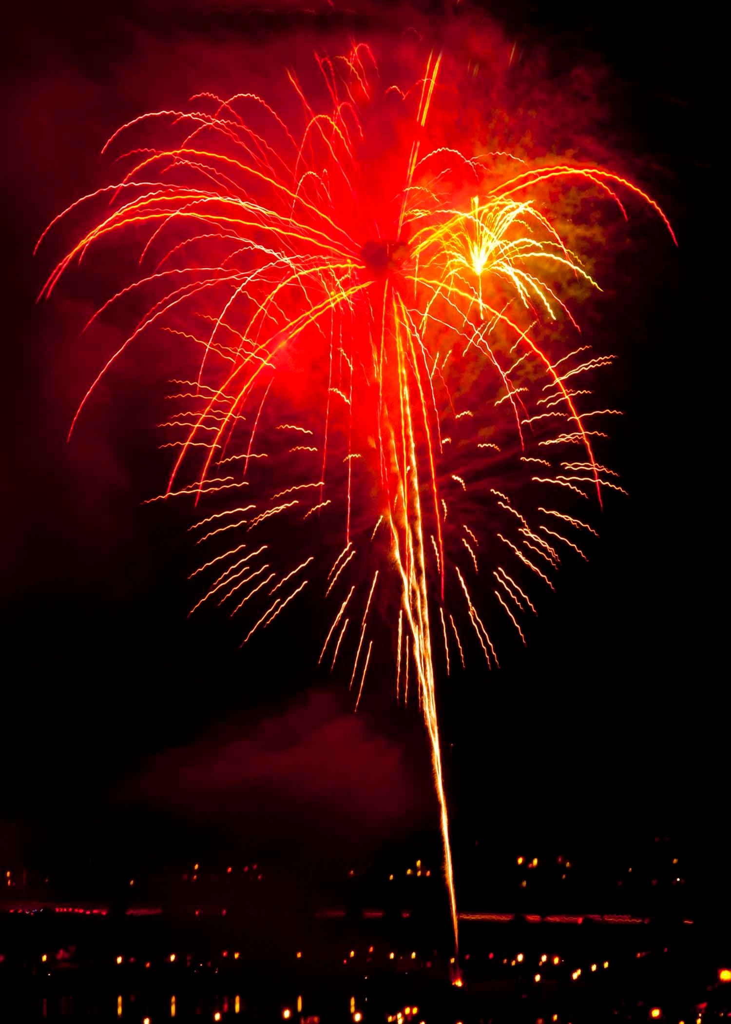Bright red fireworks burst in the night sky.