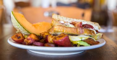 Daisy Breakfast Sandwich - Cream Cheese, Cilantro, Purple Onion & Bacon on Grilled Rosemary Bread