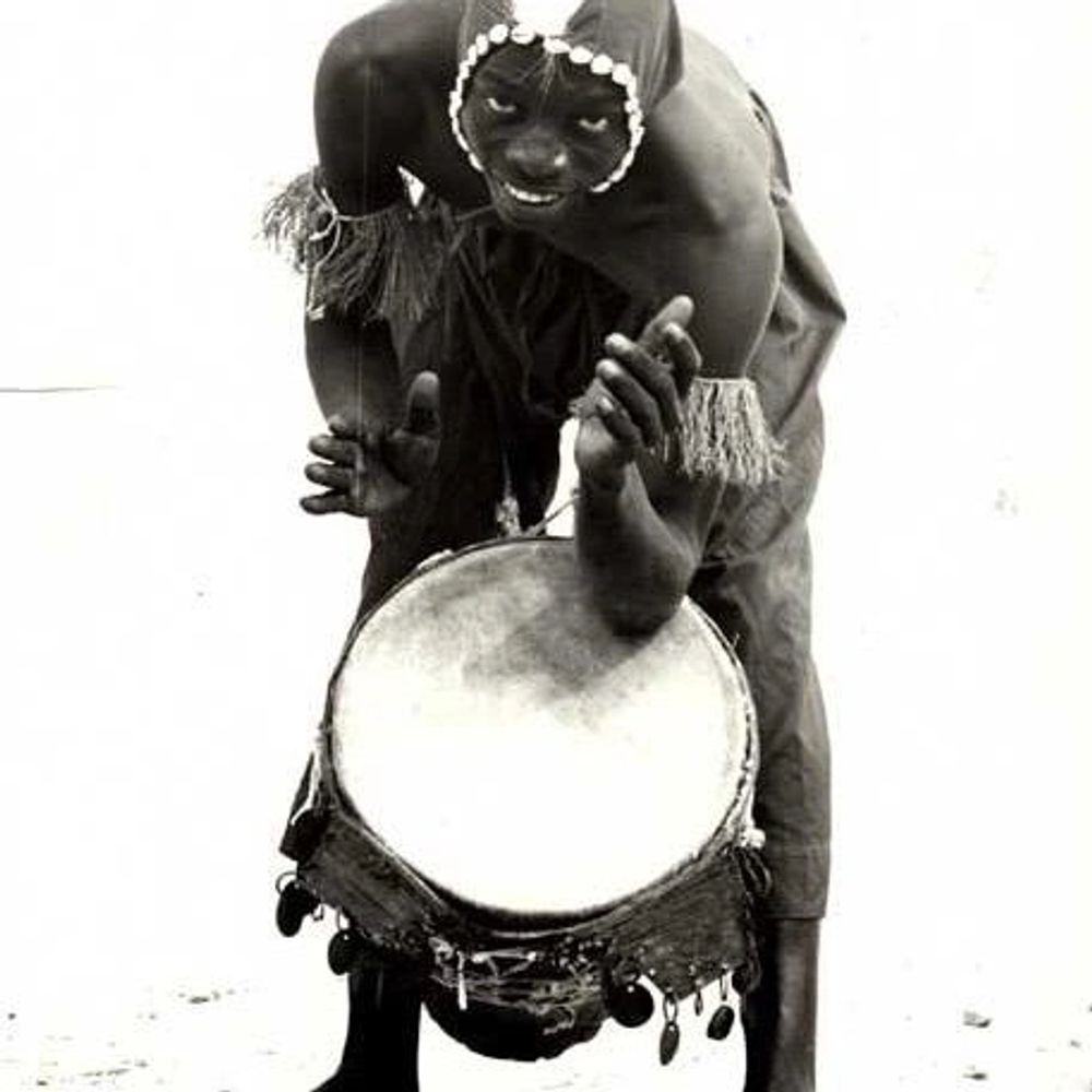 Mor Thima playing his djembe drum, wearing trditional African clothing