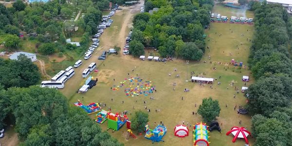 Aerial view of a park with colorful inflatables and scattered people.