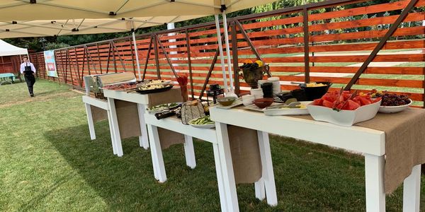 Outdoor buffet setup with various dishes under a canopy.