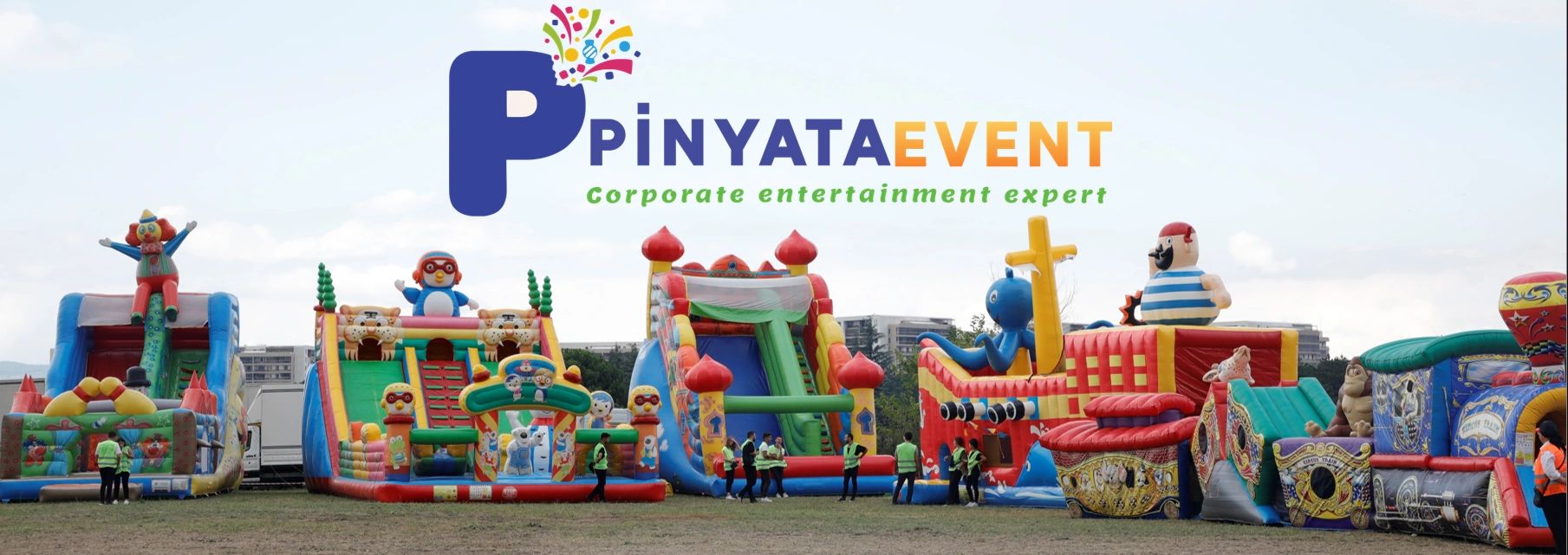 Colorful inflatable slides and bounce houses at a corporate event by PinyataEvent.