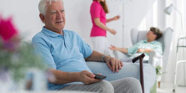 an elderly man holding the remote
