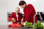 a man assisting an elderly with her food