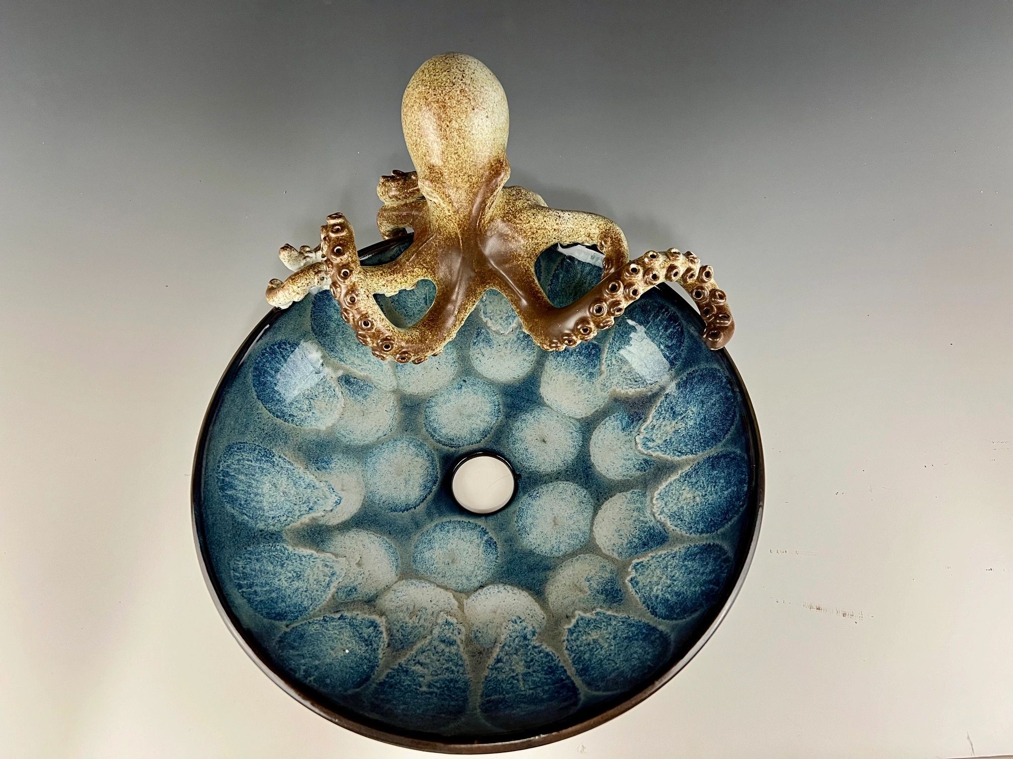 Ceramic sink with octopus sculpture.
