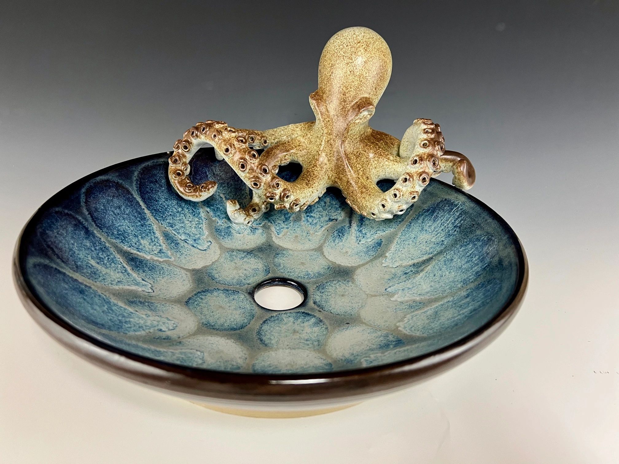 Octopus sculpture on a blue ceramic bowl.
