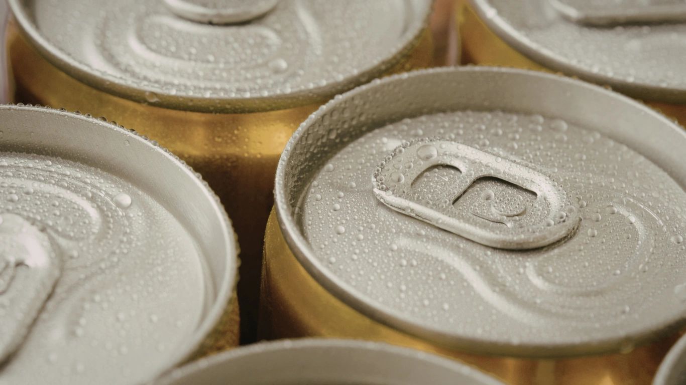 Close-up of cold beverage cans with condensation droplets on the tops.