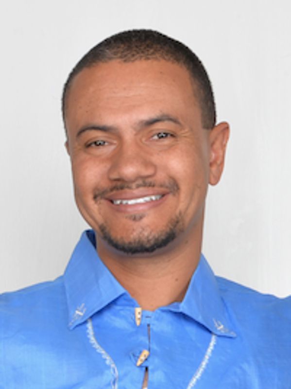 Smiling man in blue shirt with short hair and beard.