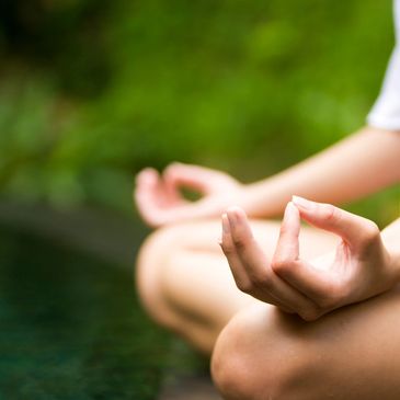Close-up of hands in a meditation mudra during outdoor yoga session.