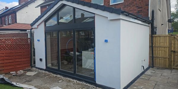 Modern house extension with large glass doors and clean white walls.