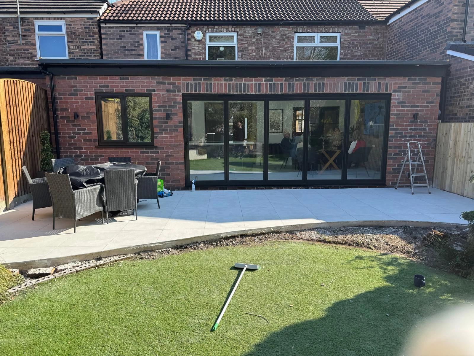 Backyard patio with outdoor furniture and large sliding glass doors.