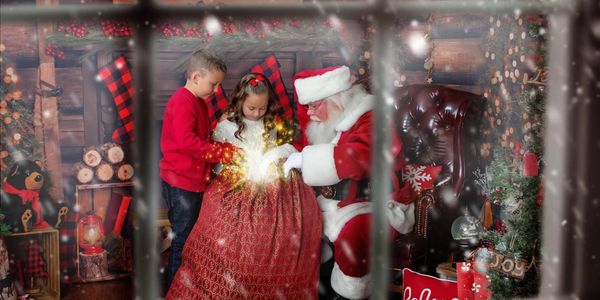 Santa opening the magic toy bag as two children look at the bright light comeing from the Santa bag