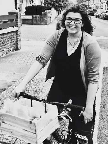 Charlotte Simpson-Orlebar riding a bike with wooden crate on front