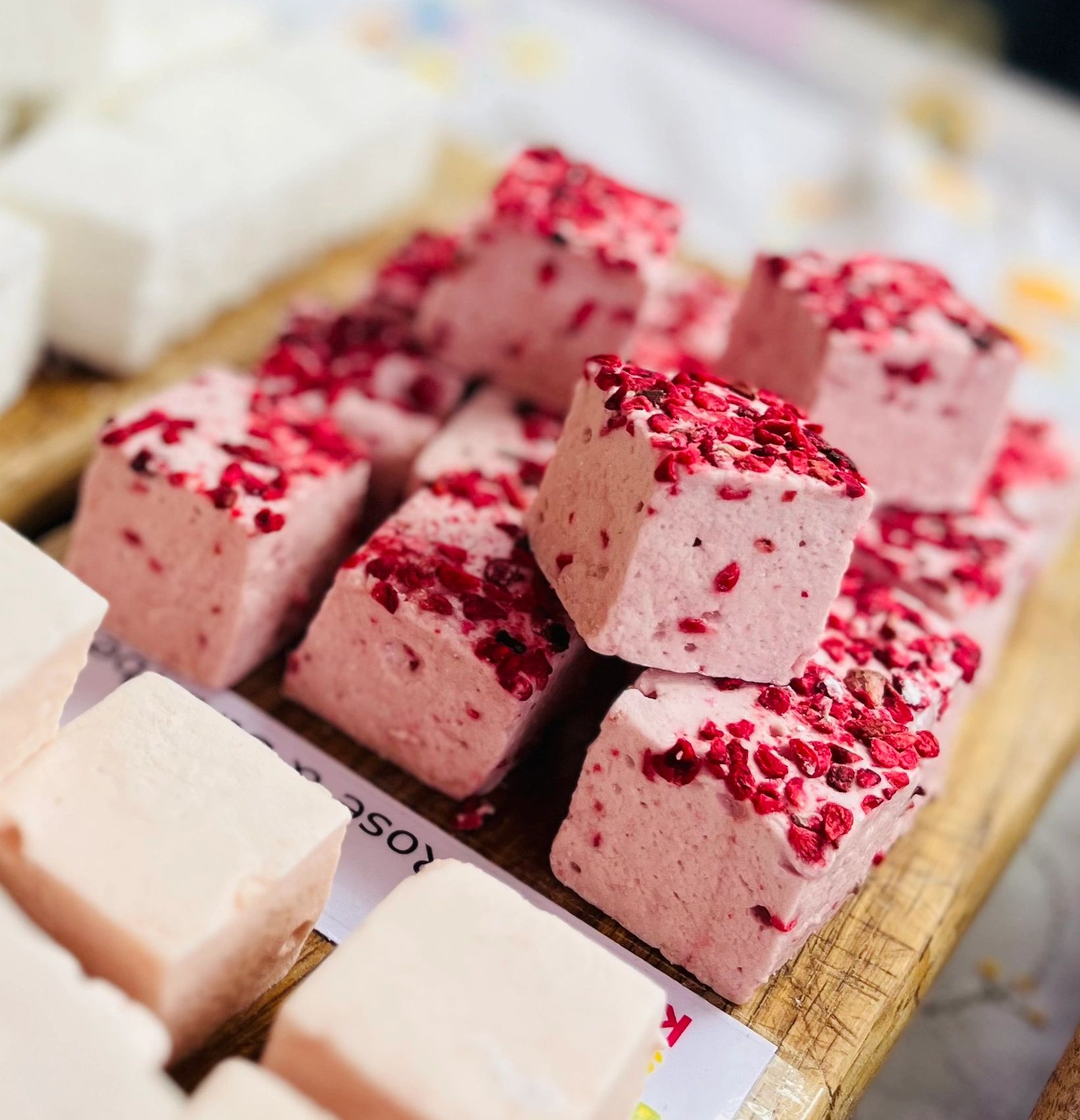 Raspberry marshmallows displayed on wooden board
