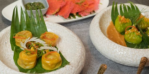 Colorful dim sum dishes served on decorative plates.