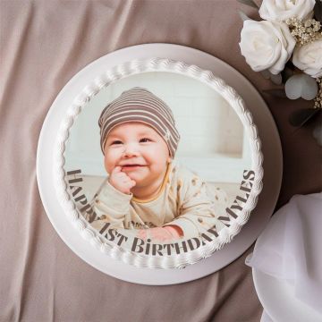 Round birthday cake with a baby's photo and text "Happy 1st Birthday Miles".