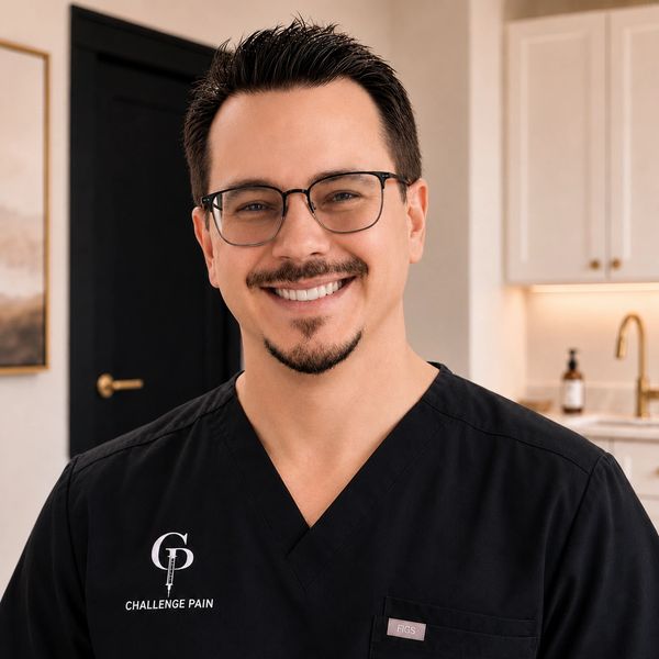 Smiling male healthcare professional in black scrubs with 'Challenge Pain' logo.