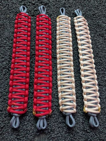 Four intricately woven paracord bracelets in red and beige with black and white loops.